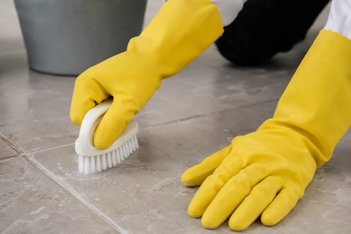 Gros plan sur la texture antidérapante de la paume d'un gant en latex jaune souple.